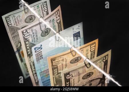 Le diverse fatture del nuovo dollaro con venti euro di fattura tra loro sono appese sullo sfondo scuro. Primo piano, messa a fuoco selettiva Foto Stock