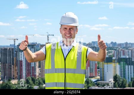 Costruttore che mostra i pollici con due mani sul tetto Foto Stock