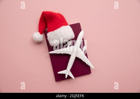 Vacanza di Natale viaggio sfondo. Aereo con passaporto e cappello rosso babbo natale Foto Stock