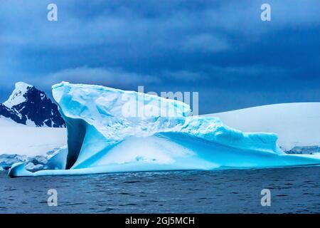 Ghiacciai Blue iceberg Snow Mountains Charlotte Bay, Antartide. Ghiaccio blu ghiaccio perché l'aria strizzava dalla neve. Foto Stock