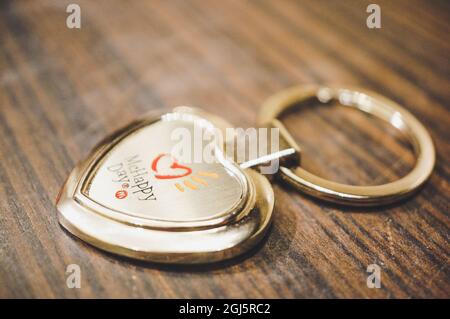 POZNAN, POLONIA - 06 feb 2017: Un portachiavi in metallo a forma di cuore McHappy Day di McDonald su un tavolo di legno Foto Stock