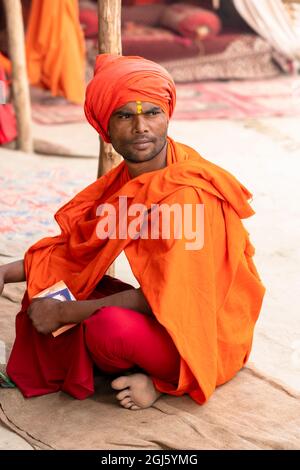 India, Utttar Pradesh, Allahabad, Prayagraj, Ardh Kumbh Mela. Ritratto di un giovane vestito di zafferano e abiti rossi. (Solo per uso editoriale) Foto Stock