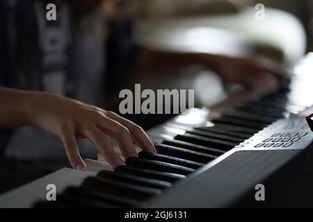 Le mani del musicista sul sintetizzatore. Immagine ritagliata di una persona che riproduce un sintetizzatore. Vista laterale. Foto di alta qualità Foto Stock