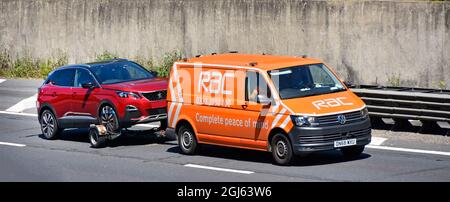 RAC VW van training Peugeot auto per il servizio di recupero guasti o trasporto di consegna auto con una completa tranquillità di business slogan autostrada UK Foto Stock