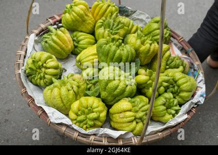 Vietnam, Hanoi, quartiere vecchio. La frutta della mano del Buddha nel cestino al mercato. Foto Stock