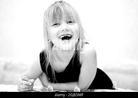 Una bambina senza due denti anteriori sorridente Foto Stock