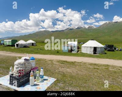 Vendita di latte, Kumiss e Kurt (yogurt secco). Yurts sul pascolo estivo vicino Tien Shan Highway. La pianura di Suusamyr, alta valle di Tien Shan mounta Foto Stock