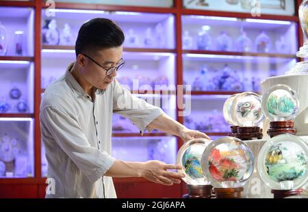 (210909) -- HENGSHUI, 9 settembre 2021 (Xinhua) -- un membro dello staff organizza all'interno di opere di pittura in un museo che presenta dipinti interni nel distretto di Taocheng di Hengshui City, nella provincia di Hebei della Cina settentrionale, 2 settembre 2021. La pittura interna, o pittura interna, è una forma d'arte cinese tradizionale. In origine coinvolge piccole bottiglie di tabacco da fiuto che hanno immagini e calligrafia dipinte sulla superficie interna della bottiglia. Le pitture della bottiglia del tabacco da fiuto sono prodotte manipolando un pennello specializzato attraverso il collo della bottiglia. Il processo di verniciatura, completamente invertito all'interno della bottiglia, richiede abs Foto Stock