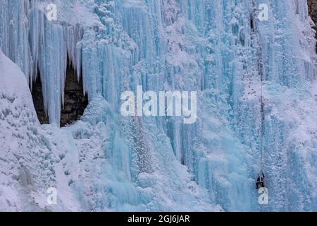 Ice climber sul piangente muro di ghiaccio nel Banff National Park, Alberta, Canada. Foto Stock