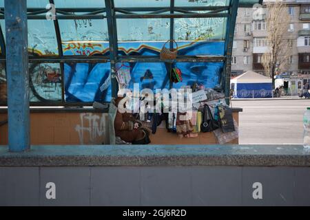 Kiev, Ucraina. Aprile 21, 2021. Il problema europeo dei poveri e dei senzatetto. Una donna mendicante vende i suoi effetti personali sulla strada di una città moderna Foto Stock