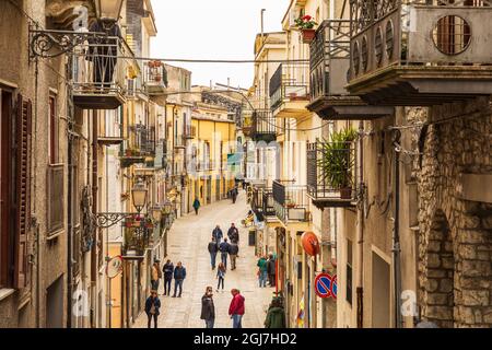 Italia, Sicilia, Provincia di Palermo, Prizzi. Aprile 21, 2019. Pedoni su una strada lastricata di Prizzi. (Solo per uso editoriale) Foto Stock