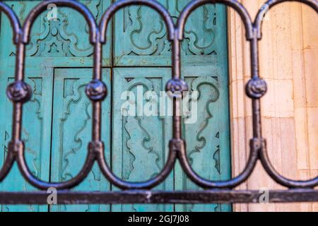 L'Italia, Puglia, provincia di Barletta-Andria-Trani, Trani. Cancellata in ferro battuto e porte blu. Foto Stock