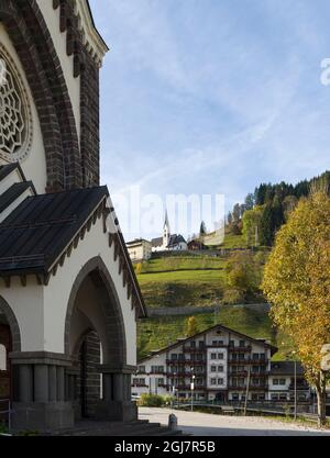 Architettura alpina tradizionale a Falcade alto in Val Biois, Chiesa di SSN Sebastiano in primo piano. Italia. Foto Stock