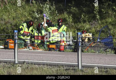 GAVLE 20130804 Emergency Workers aiutano le persone in un'auto che ha girato fuori la E16 tra Sandviken e Gavle dopo che ha colpito la striscia mediana sulla strada per il reparto di maternità all'ospedale di Gavel la domenica. La donna in macchina partorì mentre era intrappolata nella fossa. Una donna nella Svezia orientale partorì all'interno della sua auto schiantata, che si era ribaltata dall'autostrada quando suo marito notò che il suo bambino stava facendo un'apparizione precoce sulla strada per l'ospedale. Foto Roger Nilsson / SCANPIX kod 11080 Foto Stock