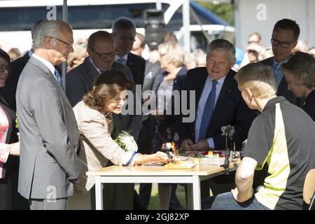 FORSHAGA 20130822Â¨ Re Carl Gustaf con la Regina Silvia è visto con un simulatore di pesca durante una visita alla High School di pesca sportiva a Forshaga, Svezia, 22 agosto 2013. La visita fa parte del 40° anniversario della KingÂ. Foto: Fredrik Sandberg / SCANPIX / Kod 10080 Foto Stock