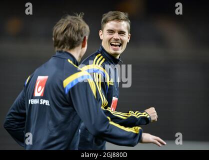 Il centrocampista svedese Mikael Lustig (R) ride durante una sessione di allenamento alla Friends Arena di Stoccolma, Svezia, il 12 novembre 2013. La squadra di calcio svedese affronterà il Portogallo venerdì in una partita di qualificazione per la Coppa del mondo 2014. Foto: Anders Wiklund / TT / code 10040 Foto Stock