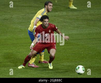 La Pepe portoghese controlla la palla davanti al calciatore svedese Johan Elmander durante la partita di calcio della seconda gamba di qualificazione della Coppa del mondo FIFA 2014 tra Svezia e Portogallo alla Friends Arena di Stoccolma il 19 novembre 2013. Foto Stock