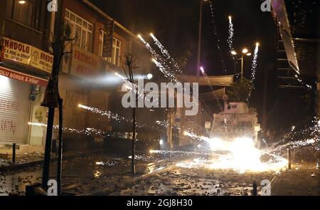 ISTANBUL 2014-05-22 manifestanti spara fuochi d'artificio. La polizia turca di sommosse usa un cannone ad acqua per disperdere i manifestanti durante una protesta contro il governo, a Istanbul, Turchia, il 22 maggio 2014. Un gruppo di manifestanti si è scontrato con la polizia di sommosse turca durante una protesta contro il governo turco che vede responsabile dell'esplosione della miniera di Soma. Secondo quanto riferito, l'AKP del primo ministro Recep Tayyip Erdogan ha respinto in aprile una mozione del Partito popolare Repubblicano (CHP) di centro-sinistra per rivedere la sicurezza nella miniera di Soma. La peggiore catastrofe mineraria della storia del paese ha lasciato almeno 301 lavoratori morti. Foto di Foto Stock