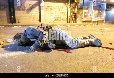 ISTANBUL 2014-05-22 un uomo ferito si trova sul campo, quando i manifestanti si scontrano con la polizia a Istanbul, in Turchia, alla fine di giovedì 22 marzo 2014. Un altro manifestante è stato gravemente ferito durante gli scontri del giorno. La polizia turca di sommosse usa un cannone ad acqua per disperdere i manifestanti durante una protesta contro il governo, a Istanbul, Turchia, il 22 maggio 2014. Un gruppo di manifestanti si è scontrato con la polizia di sommosse turca durante una protesta contro il governo turco che vede responsabile dell'esplosione della miniera di Soma. Secondo quanto riferito, l'AKP del primo ministro Recep Tayyip Erdogan ha respinto una mozione del popolo di centro-sinistra Foto Stock