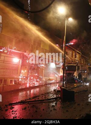 ISTANBUL 2014-05-22 manifestanti spara fuochi d'artificio. La polizia turca di sommosse usa un cannone ad acqua per disperdere i manifestanti durante una protesta contro il governo, a Istanbul, Turchia, il 22 maggio 2014. Un gruppo di manifestanti si è scontrato con la polizia di sommosse turca durante una protesta contro il governo turco che vede responsabile dell'esplosione della miniera di Soma. Secondo quanto riferito, l'AKP del primo ministro Recep Tayyip Erdogan ha respinto in aprile una mozione del Partito popolare Repubblicano (CHP) di centro-sinistra per rivedere la sicurezza nella miniera di Soma. La peggiore catastrofe mineraria della storia del paese ha lasciato almeno 301 lavoratori morti. Foto di Foto Stock