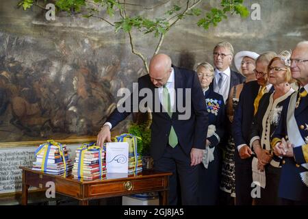 STOCCOLMA 2014-06-08 primo ministro Fredrik Reinfeldt con il presente del governo e del Parlamento, libri per bambini, dopo la cerimonia di battesimo per la Principessa Leonore nella Cappella del Palazzo reale di Drottningholm vicino Stoccolma, Svezia 8 giugno 2014. Il cavallo era un regalo per la principessa Leonore che è la Dutchessa di Gotland givn dal conttuoso generale Cecilia Schelin Seidegard. La Principessa Leonore è figlia della Principessa Madeleine di Svezia e del signor Christopher OÃ‚Â´Neill e della nipote del re Carl XVI Gustaf di Svezia. Il Palazzo Drottningholm è la residenza del re Carl Gust Foto Stock