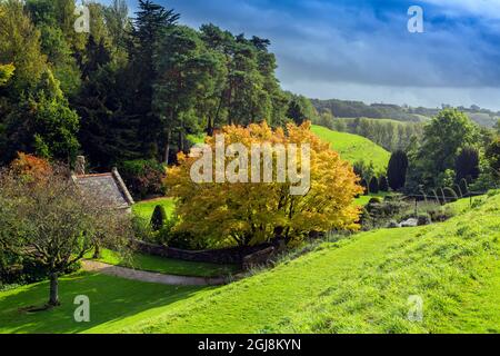 L'autunno si tinte intorno alla casa estiva che si affaccia sul giardino della piscina a Mapperton House, Dorset, Inghilterra, Regno Unito Foto Stock