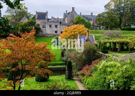 L'autunno si tinte intorno alla casa estiva che si affaccia sul giardino della piscina a Mapperton House, Dorset, Inghilterra, Regno Unito Foto Stock