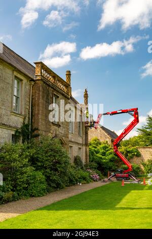 Manutenzione del tessuto esterno dell'edificio utilizzando un selezionatore di ciliegi e scale presso la storica Jacobean Mapperton House, Dorset, Inghilterra, Regno Unito Foto Stock