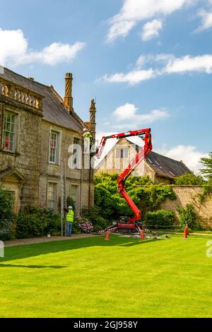 Manutenzione del tessuto esterno dell'edificio utilizzando un selezionatore di ciliegi e scale presso la storica Jacobean Mapperton House, Dorset, Inghilterra, Regno Unito Foto Stock