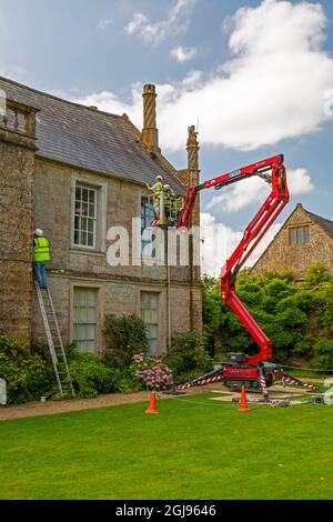 Manutenzione del tessuto esterno dell'edificio utilizzando un selezionatore di ciliegi e scale presso la storica Jacobean Mapperton House, Dorset, Inghilterra, Regno Unito Foto Stock