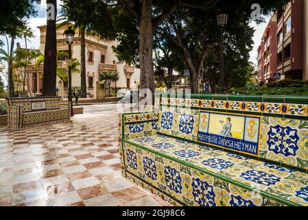 Spagna Isole Canarie Tenerife Island, Santa Cruz de Tenerife, Plaza 25 de Julio, nei primi anni del XX secolo park con panchine coperte in pubblicità di antiquariato Foto Stock