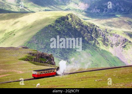 Ferrovia di montagna, Snowdonia, Galles del Nord. Il treno a vapore parte dalla città di Llanberis nella valle fino alla cima del Monte Snowden. Paesaggista rurale Foto Stock