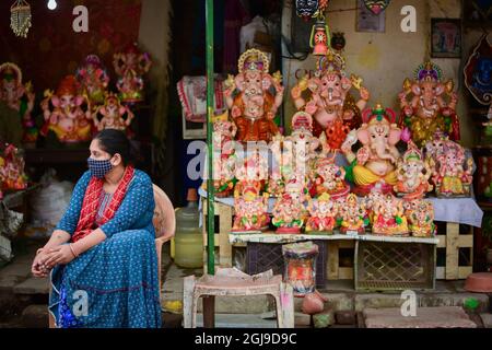 New Delhi, India. 9 settembre 2021. Un artista attende i clienti di fronte alla sua stalla con idoli di elefante capeggiato Dio Hindu Ganesha, esposto per la vendita in preparazione per il prossimo festival. I devoti indù si preparano per il festival di Ganesh Chaturthi a Nuova Delhi. Il festival indù di Ganesh Chaturthi è celebrato come l'anniversario di nascita di Lord Ganesh e dura 10 giorni. Credit: SOPA Images Limited/Alamy Live News Foto Stock