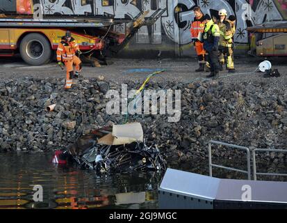 ** NUOVE INFORMAZIONI! I cinque uomini uccisi nel ponte auto crash sono stati cittadini britannici ** SODERTALJE 2016-02-13 Una macchina gravemente danneggiata è trainata dal canale sotto il ponte autostradale E4 a Sodertalje, Svezia, 13 febbraio 2016. La polizia di domenica ha confermato che i cinque uomini uccisi quando la loro auto ha attraversato il cancello e volato fuori dal ponte autostradale aperto 29 metri di altezza presto Sabato mattina sono cittadini britannici. Il ponte era stato aperto per permettere ad una nave da carico di passare sotto di esso e altre auto si erano fermate davanti al cancello e luci rosse. È in corso un'indagine sul motivo per cui la vettura in crash non è riuscita a fermarsi. Foto: Foto Stock