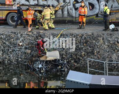 ** NUOVE INFORMAZIONI! I cinque uomini uccisi nel ponte auto crash sono stati cittadini britannici ** SODERTALJE 2016-02-13 Una macchina gravemente danneggiata è trainata dal canale sotto il ponte autostradale E4 a Sodertalje, Svezia, 13 febbraio 2016. La polizia di domenica ha confermato che i cinque uomini uccisi quando la loro auto ha attraversato il cancello e volato fuori dal ponte autostradale aperto 29 metri di altezza presto Sabato mattina sono cittadini britannici. Il ponte era stato aperto per permettere ad una nave da carico di passare sotto di esso e altre auto si erano fermate davanti al cancello e luci rosse. È in corso un'indagine sul motivo per cui la vettura in crash non è riuscita a fermarsi. Foto: Foto Stock