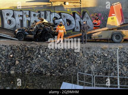 ** NUOVE INFORMAZIONI! I cinque uomini uccisi nel ponte auto crash sono stati cittadini britannici ** SODERTALJE 2016-02-13 Una macchina gravemente danneggiata è trainata dal canale sotto il ponte autostradale E4 a Sodertalje, Svezia, 13 febbraio 2016. La polizia di domenica ha confermato che i cinque uomini uccisi quando la loro auto ha attraversato il cancello e volato fuori dal ponte autostradale aperto 29 metri di altezza presto Sabato mattina sono cittadini britannici. Il ponte era stato aperto per permettere ad una nave da carico di passare sotto di esso e altre auto si erano fermate davanti al cancello e luci rosse. È in corso un'indagine sul motivo per cui la vettura in crash non è riuscita a fermarsi. Foto: Foto Stock