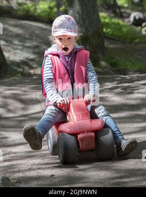 STOCCOLMA 20150528 Una ragazza sta cavalcando un'auto giocattolo in un parco giochi Foto Jonas Ekstromer / TT / kod 1003 play ground, telaio di arrampicata, Foto Stock