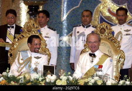 Â SCANPIX SVEZIA 20040207 Bandar seri Begawan, Brunei. DET svenska kungaparet pa statsbesok i Brunei. Bilden: Sultan Hassanal Bolkiah och King Carl Gustaf hade det riktigt trevligt sotto lordagskvallens bankett i palatset Istana Nurul Iman. Kungen i vit banda laterale med gult uniforme. Foto Anders Wiklund / SCANPIX Code 50030 il re svedese Carl XVI Gustaf festeggerà il suo settantesimo compleanno il 30 aprile 2016. Foto Stock