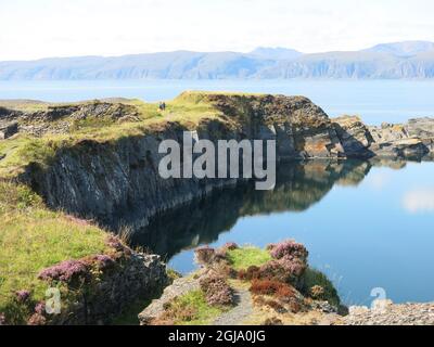 Scenario suggestivo di scogliere aspre e acque blu limpide del mare: L'ex isola di estrazione ardesia di Easdale al largo della costa occidentale della Scozia. Foto Stock