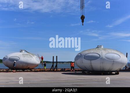 NORRKOPING 20160622 due case futuro nel porto di Norrkoping, Svezia. Futuro, o futura House, è una casa rotonda prefabbricata progettata da Matti Suuronen in Finlandia. Meno di 100 furono costruiti alla fine degli anni sessanta e all'inizio degli anni settanta e solo 60 sono sopravvissuti. La caratteristica forma simile a un piatto volante e l'entrata del portello dell'aeroplano hanno reso le case popolari fra i collettori. Il futuro è composto da plastica poliestere rinforzata con fibra di vetro, poliestere-poliuretano, e poli(metilmetacrilato), con un'altezza di 13 piedi (4 metri) e un diametro di 26 piedi (8 metri). Era un trasporto universale Foto Stock
