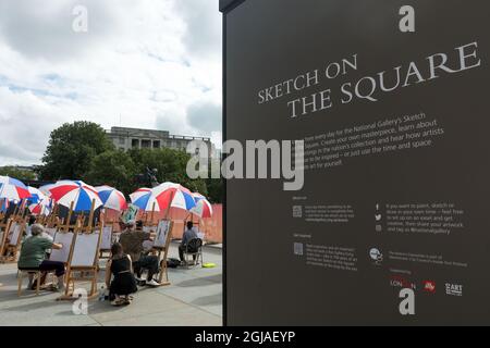 La gente ha visto disegnare a Trafalgar Square sotto gli ombrelloni.'Scetch on the Square' è un programma d'arte gratuito organizzato dalla National Gallery, in collaborazione con Art of London, come parte del festival Inside out. 30 cavalletti sono allestiti a Trafalgar Square per la pittura. Foto Stock