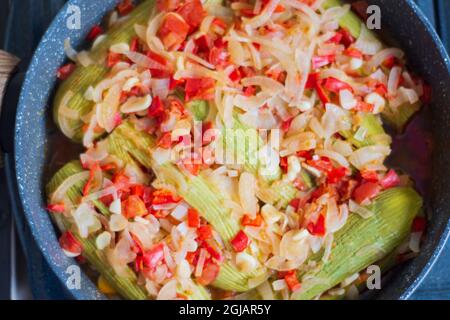 Zucchine con olio d'oliva. Si cuoce con cipolle tritate finemente, peperoni e aglio. Cucina mediterranea. Foto Stock