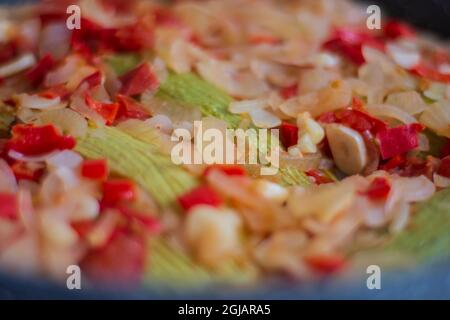 Zucchine con olio d'oliva. Si cuoce con cipolle tritate finemente, peperoni e aglio. Cucina mediterranea. Foto Stock