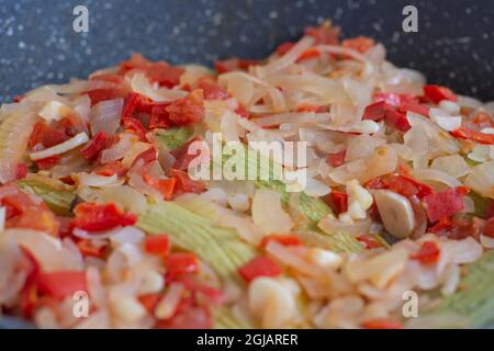 Zucchine con olio d'oliva. Si cuoce con cipolle tritate finemente, peperoni e aglio. Cucina mediterranea. Foto Stock