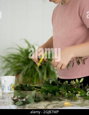 La bambina e la zia stanno pulendo i rami dell'albero che hanno raccolto dal giardino. Rami di fuoco selettivi. Foto Stock