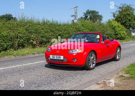 2006, rosso Mazda MX-5 Sport 6 velocità manuale 1999cc benzina cabrio, in rotta per Capesthorne Hall classica auto mostra di luglio, Cheshire, Regno Unito Foto Stock