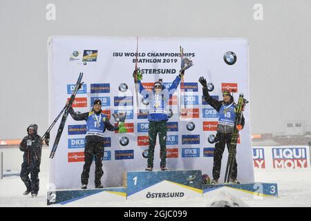 CORRECTION ORDER (L-R) secondo classificato Antonin Guigonnat di Francia, vincitore Dominik Windisch d'Italia e terzo classificato Julian Eberhard di Svizzera festeggia sul podio dopo la gara di massa maschile di 15 km al campionato mondiale di Biathlon IBU di Oestersund, Svezia, il 17 marzo 2019. Foto: Jessica Gow / TT / code 10070 Foto Stock