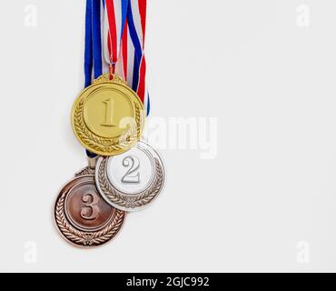 Medaglie, oro, argento e bronzo. Vincitori, premio atleti podio concetto trofeo. Primo, secondo e terzo posto premio appeso da rosso blu nastro i Foto Stock