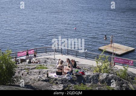 I contadini godono di una giornata estiva soleggiata al lago Malaren come un segno sociale di allontanamento appeso su una recinzione, in mezzo alla malattia di coronavirus (COVID-19) focolaio, a Stoccolma, Svezia, il 31 luglio 2020. Poto: Naina Helen Jama / TT / code 11880 *** SWEDEN OUT *** Foto Stock