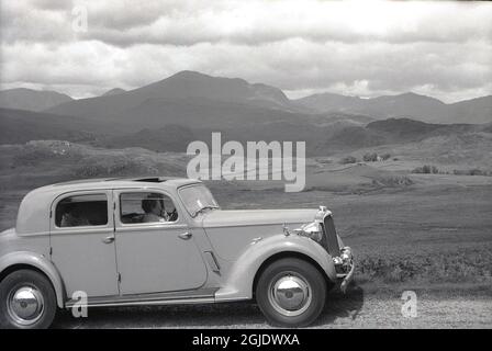 Anni '50, storico, automobilismo nelle Highlands scozzesi, due donne sedute in un'auto di Rover fabbricata in Inghilterra, una Rover 75 P3 berlina sportiva a 4 luci, parcheggiata sul lato di una strada di campagna, Scozia, Regno Unito. Foto Stock